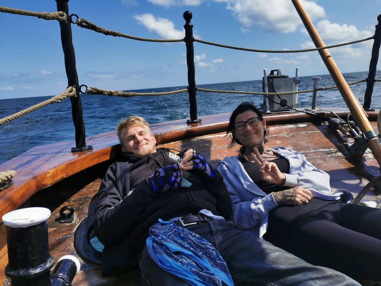 Eine junge Frau und ein junger Mann liegen an Deck eines Schiffs und genießen 