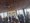 Gruppe von Menschen in Anzügen unterhält sich in einem modernen Raum mit großen Fenstern. Im Hintergrund wird auf einer Leinwand ein Gruppenfoto projiziert. Die Szenerie deutet auf ein Networking-Event oder eine Konferenzpause hin.