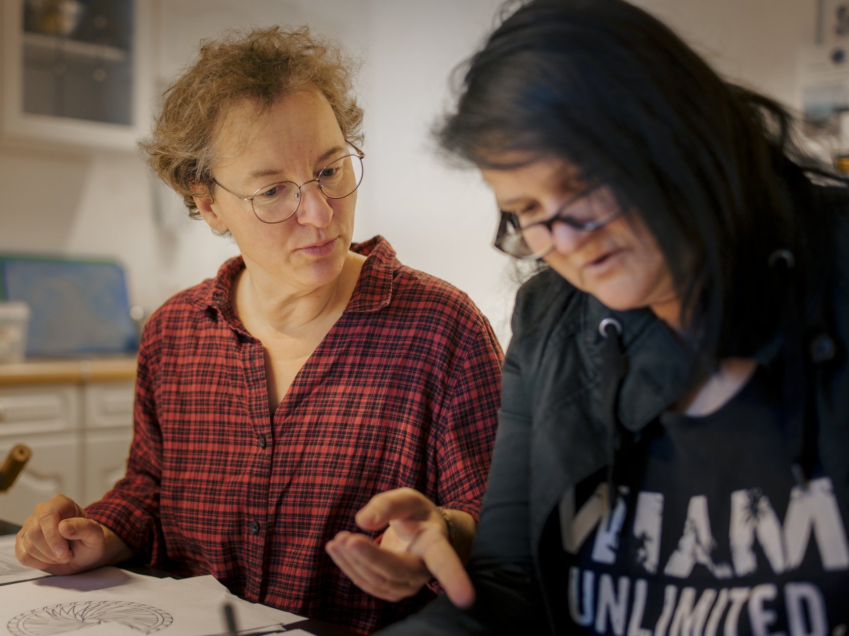 zwei Frauen schauen unterhalten sich über Mandalas